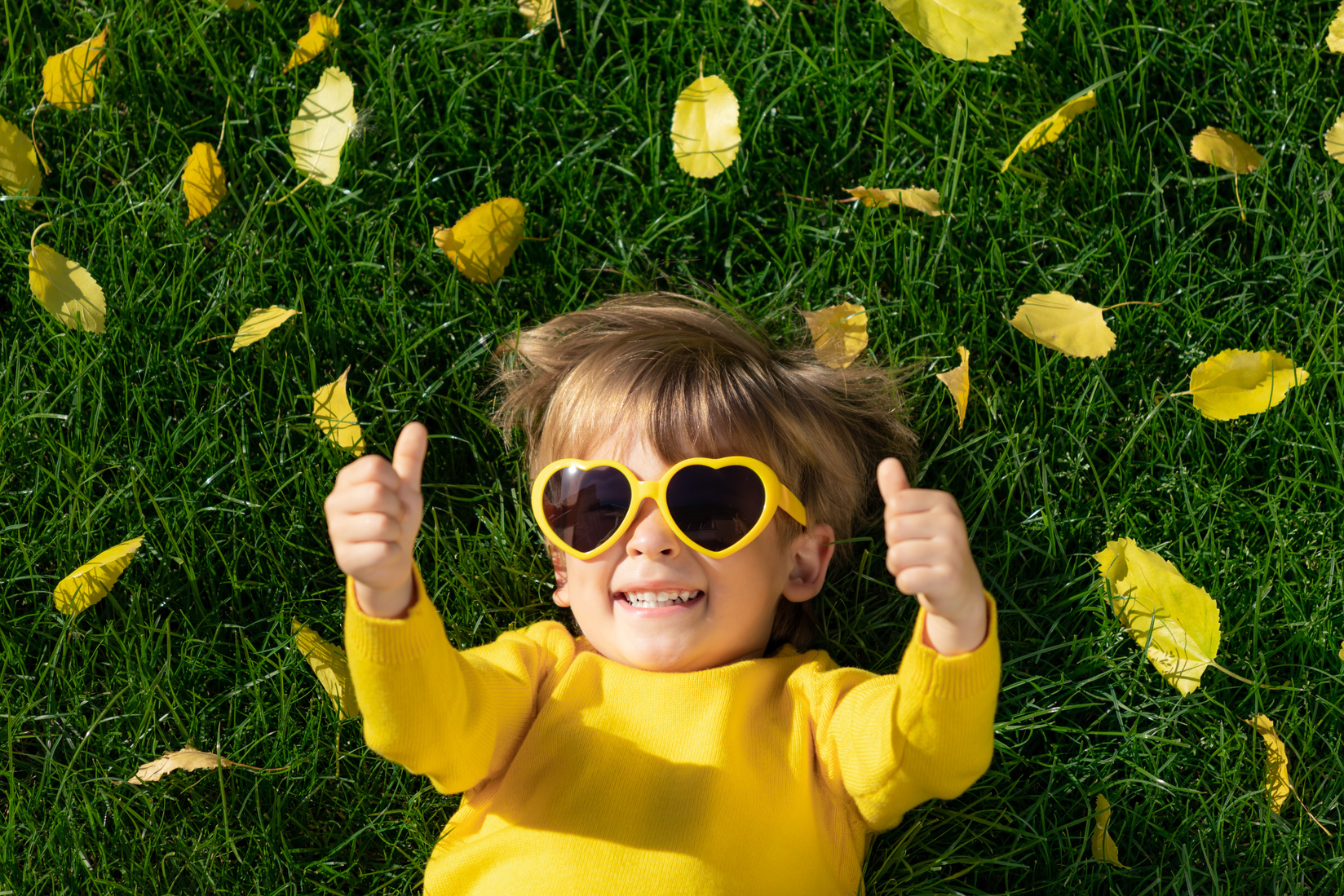 Happy Kid Having Fun While Lying on Grass